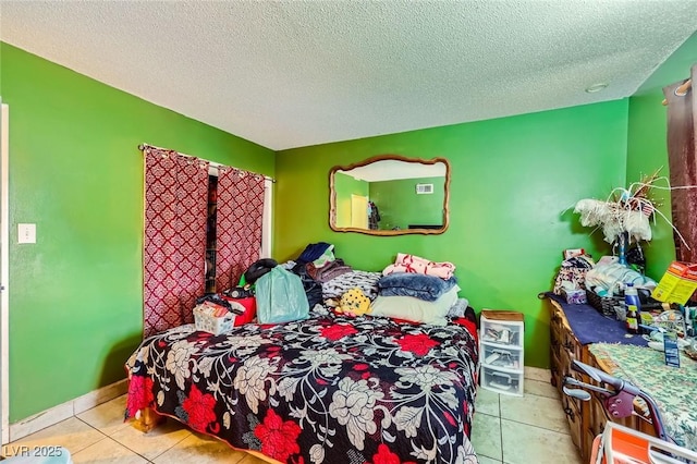 bedroom featuring light tile patterned flooring, baseboards, and a textured ceiling