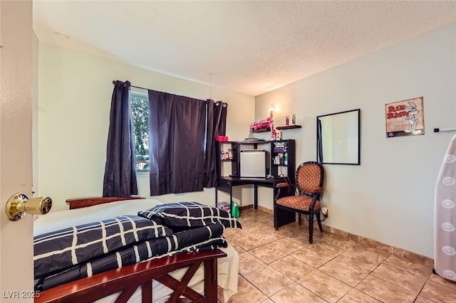 bedroom featuring light tile patterned floors and a textured ceiling