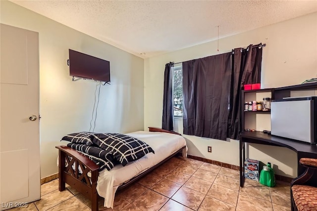 bedroom featuring tile patterned flooring, baseboards, and a textured ceiling