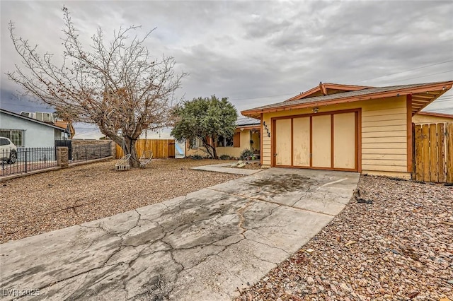 view of yard with an attached garage, fence, and driveway