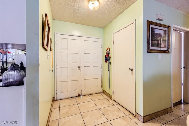 foyer entrance featuring light tile patterned floors and a textured ceiling