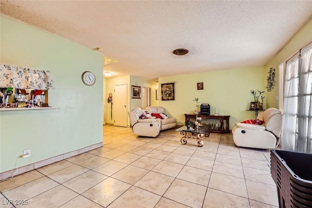 living area featuring light tile patterned floors, visible vents, and a textured ceiling