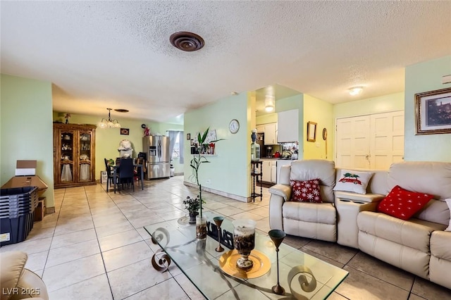 living area with a chandelier, a textured ceiling, and light tile patterned flooring