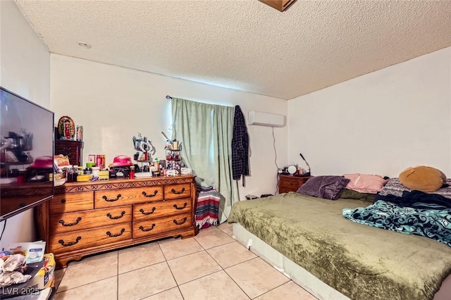 bedroom featuring light tile patterned floors, a wall mounted air conditioner, and a textured ceiling