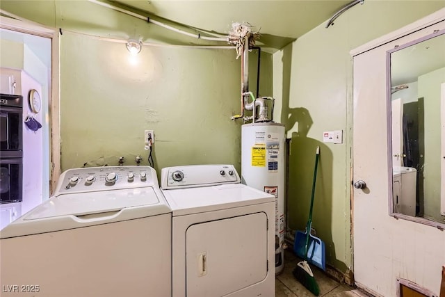 clothes washing area with washer and dryer, gas water heater, and laundry area