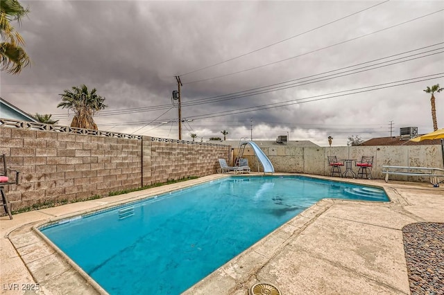 view of swimming pool featuring a fenced in pool, a patio, a water slide, and a fenced backyard