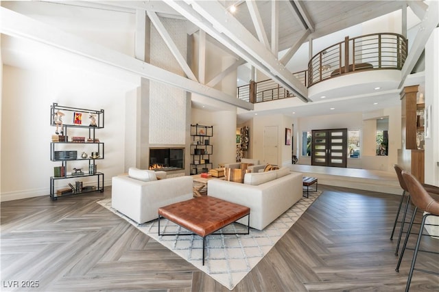 living room featuring beamed ceiling, a large fireplace, parquet flooring, and high vaulted ceiling