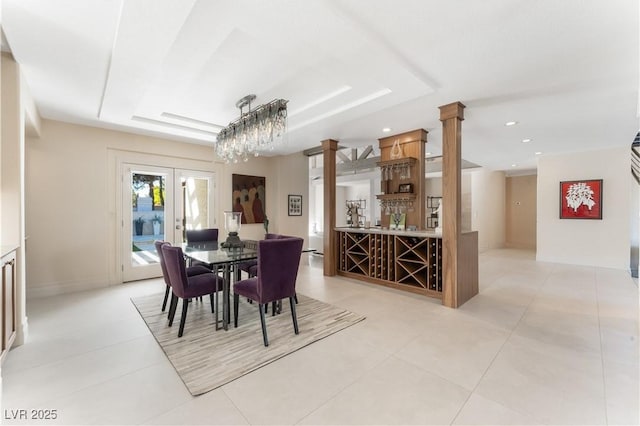 tiled dining room with a raised ceiling and bar