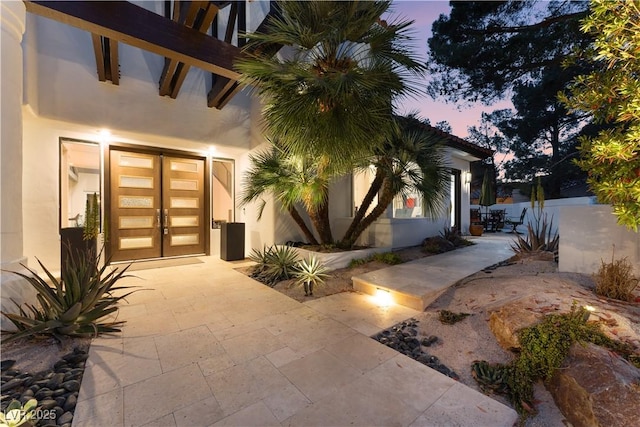 exterior entry at dusk with a patio and french doors