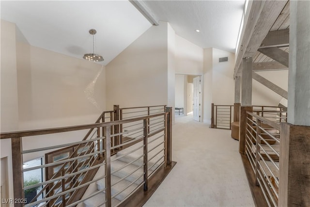 corridor featuring beamed ceiling, carpet floors, and high vaulted ceiling