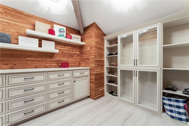 walk in closet with vaulted ceiling with beams