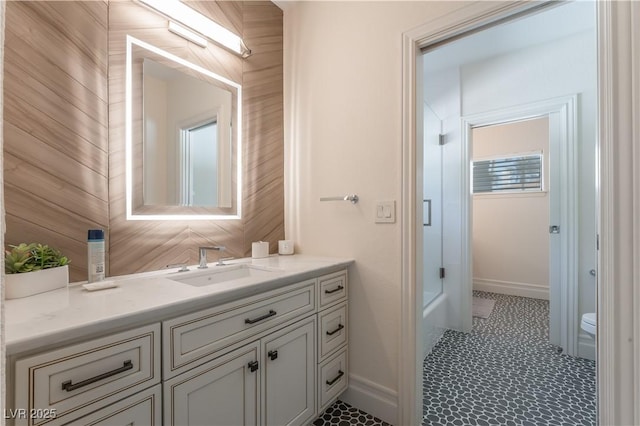 bathroom featuring wood walls, vanity, and toilet