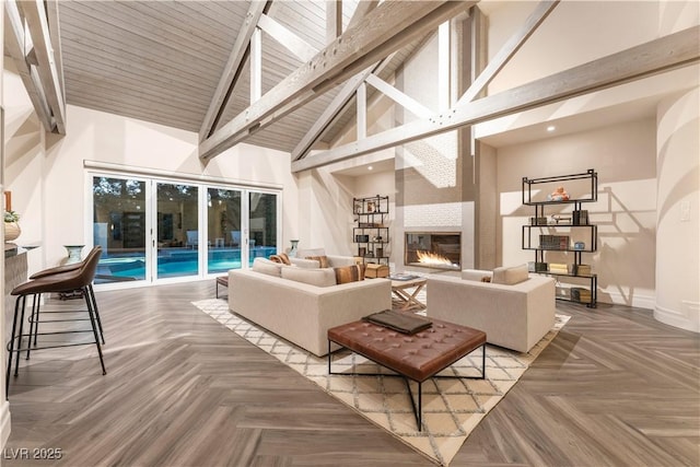 living room with parquet flooring, beam ceiling, high vaulted ceiling, and a fireplace