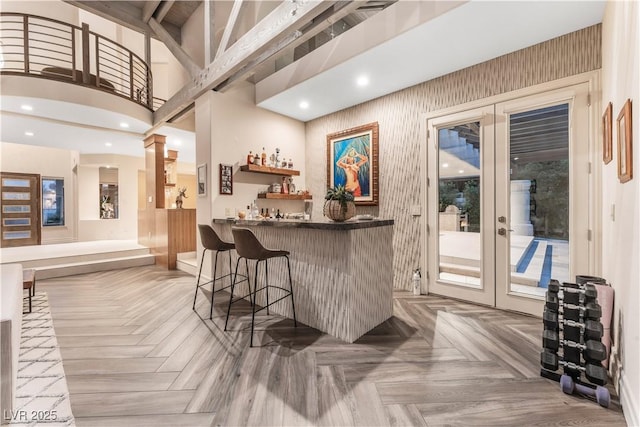 bar featuring french doors, parquet floors, and a high ceiling