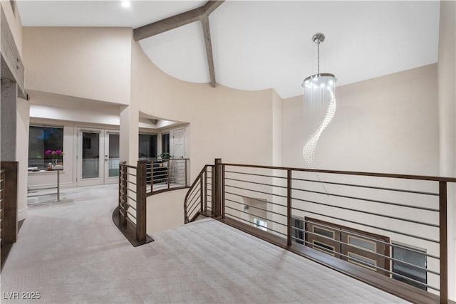 staircase featuring a notable chandelier, beam ceiling, carpet floors, and high vaulted ceiling