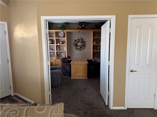 hall featuring dark colored carpet