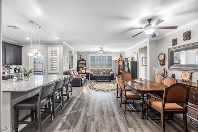 dining room with ceiling fan, dark wood-type flooring, and ornamental molding