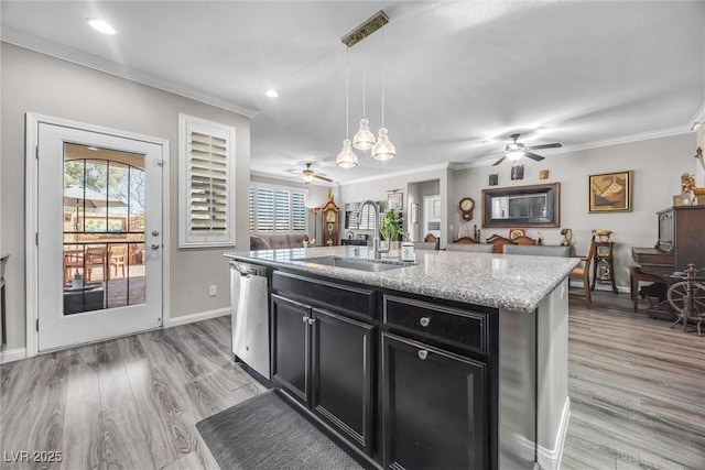 kitchen with light stone counters, a kitchen island with sink, sink, decorative light fixtures, and dishwasher