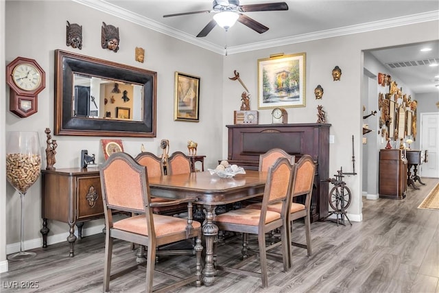 dining room featuring light hardwood / wood-style floors, ceiling fan, and ornamental molding