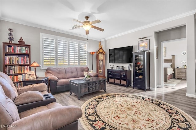 living room featuring light hardwood / wood-style floors, ceiling fan, and ornamental molding