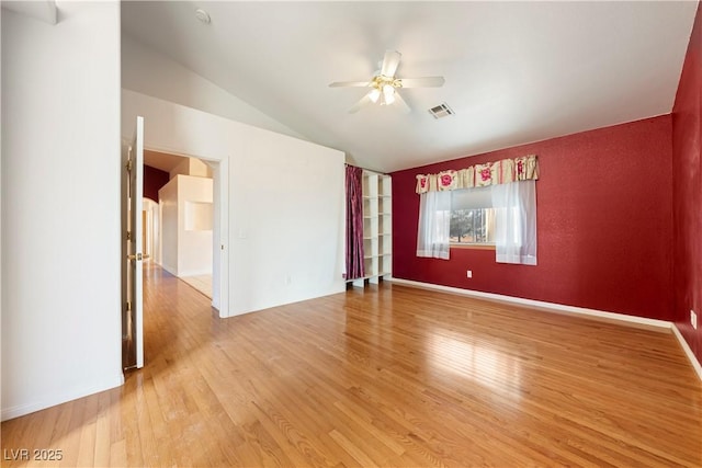 spare room featuring hardwood / wood-style flooring, ceiling fan, and lofted ceiling