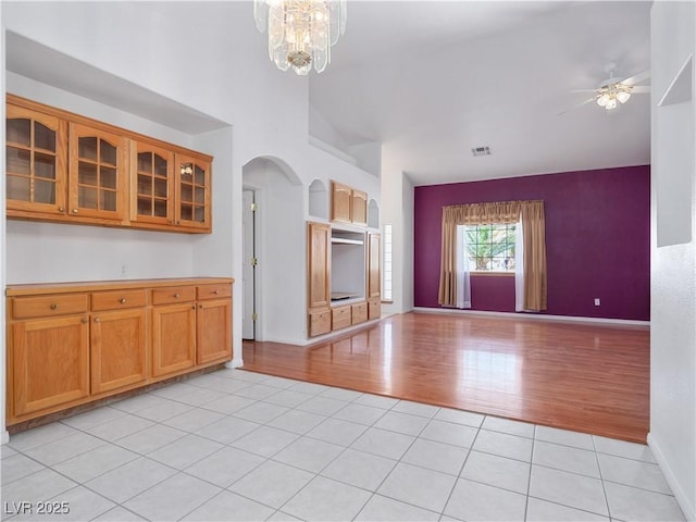 kitchen with ceiling fan with notable chandelier and light tile patterned flooring