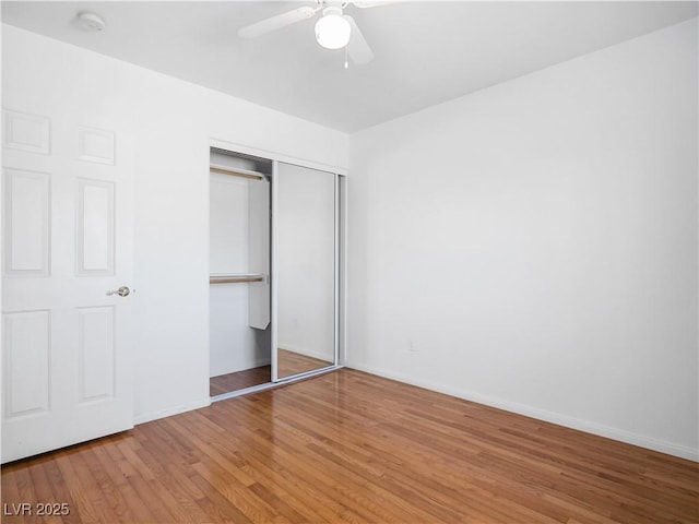 unfurnished bedroom with wood-type flooring, a closet, and ceiling fan