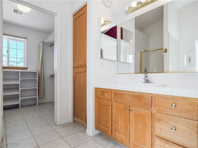 bathroom featuring tile patterned floors, vanity, and walk in shower