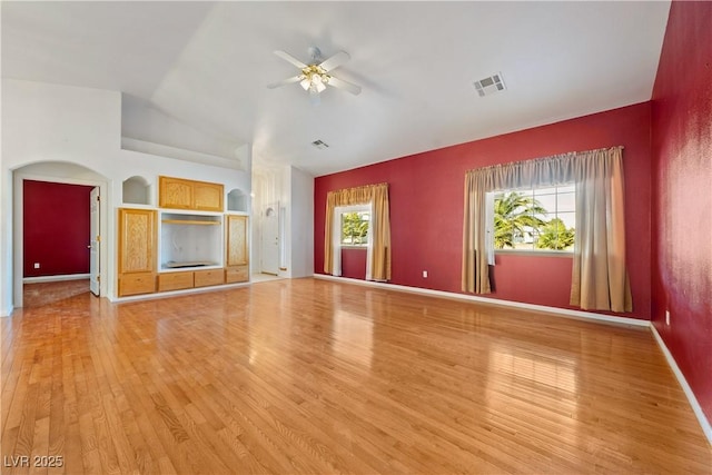 unfurnished living room featuring ceiling fan, light wood-type flooring, and vaulted ceiling