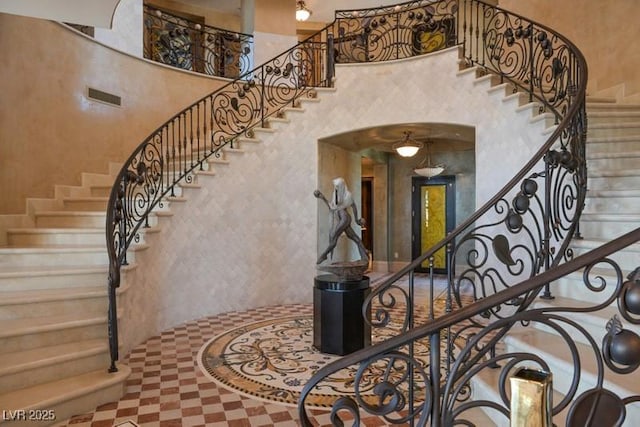 staircase featuring a high ceiling