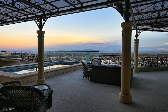 patio terrace at dusk featuring a jacuzzi and a pergola