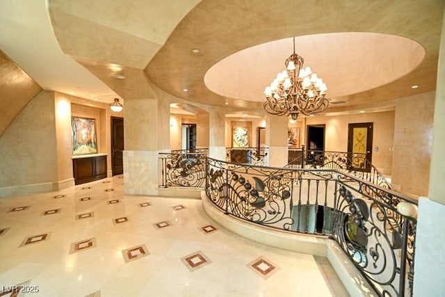 hall featuring a chandelier and a tray ceiling