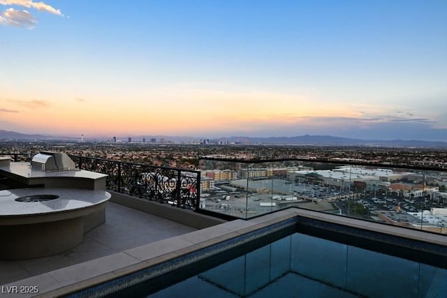 balcony at dusk featuring area for grilling