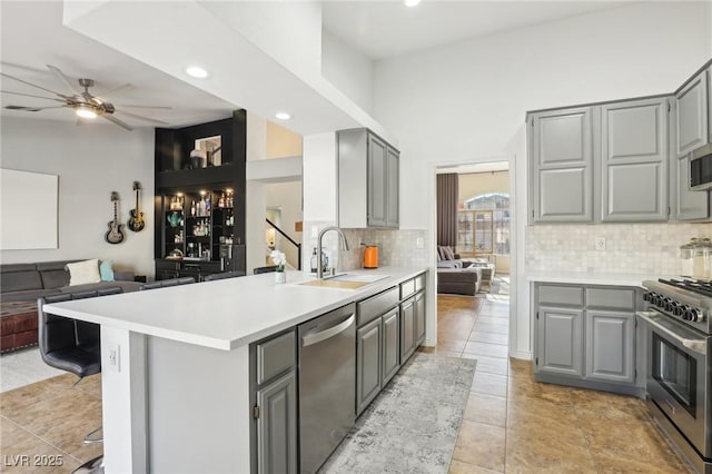 kitchen featuring sink, stainless steel appliances, gray cabinets, and kitchen peninsula