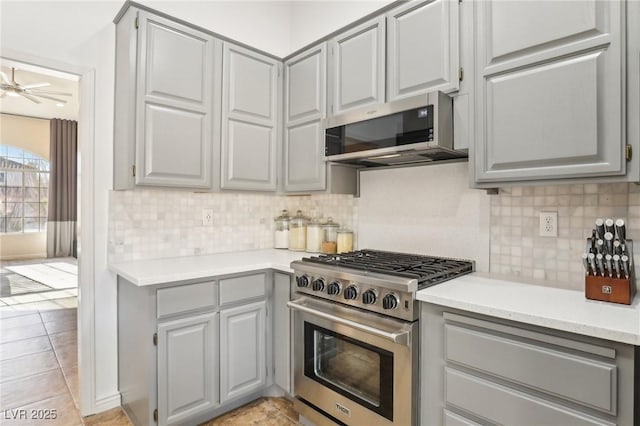 kitchen with light tile patterned floors, appliances with stainless steel finishes, ceiling fan, and gray cabinets