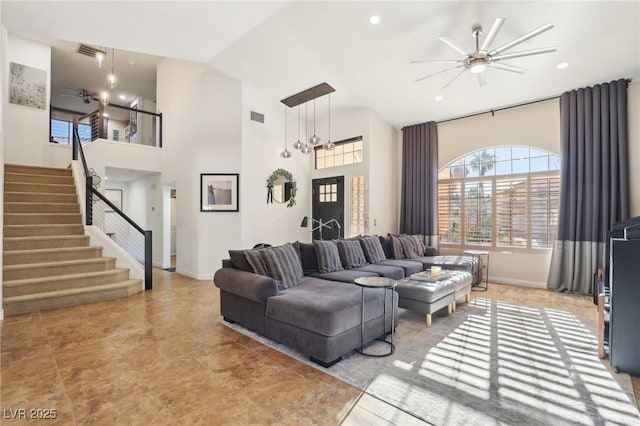 living room with ceiling fan and a high ceiling