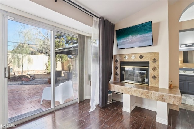 interior space featuring a tile fireplace and vaulted ceiling