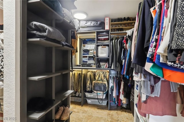 spacious closet with light tile patterned floors