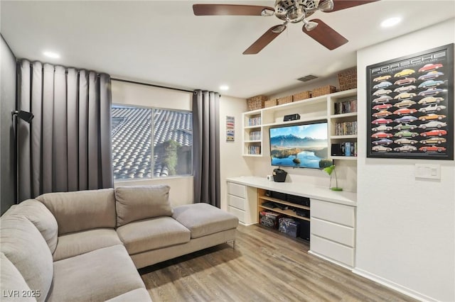 living room with ceiling fan and light hardwood / wood-style flooring