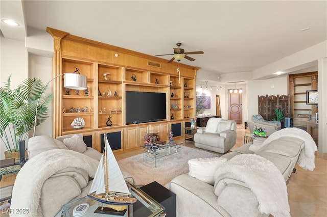 tiled living room with ceiling fan and built in features