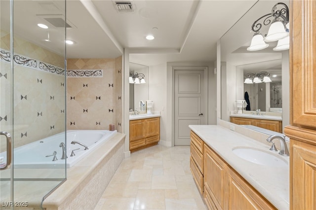 bathroom with vanity and shower with separate bathtub