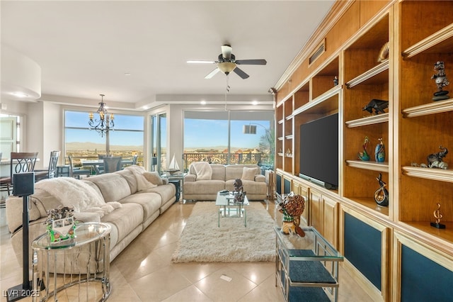 tiled living room featuring ceiling fan with notable chandelier and built in shelves