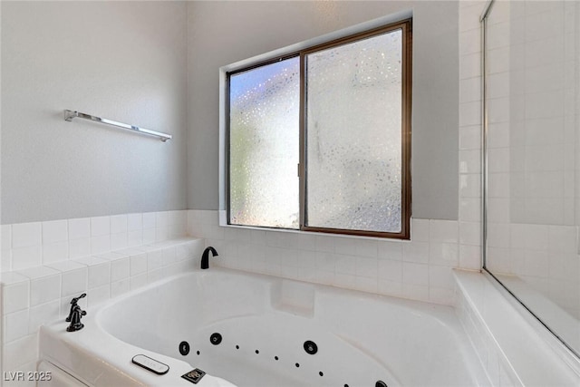 full bathroom with a whirlpool tub and a wealth of natural light