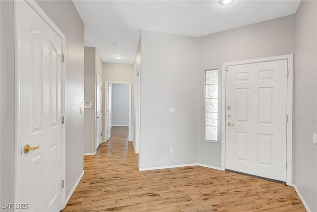 foyer with baseboards and light wood-type flooring