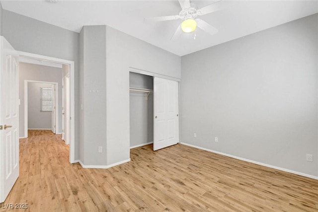 unfurnished bedroom featuring a closet, a ceiling fan, light wood-type flooring, and baseboards