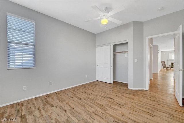 unfurnished bedroom featuring light wood-style flooring, baseboards, a closet, and ceiling fan