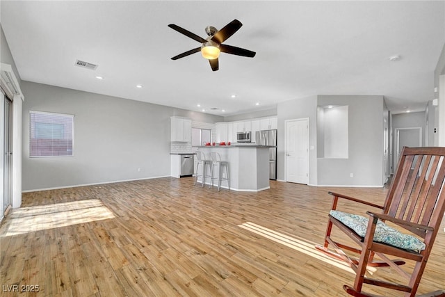 unfurnished living room featuring recessed lighting, visible vents, light wood-style flooring, and a ceiling fan