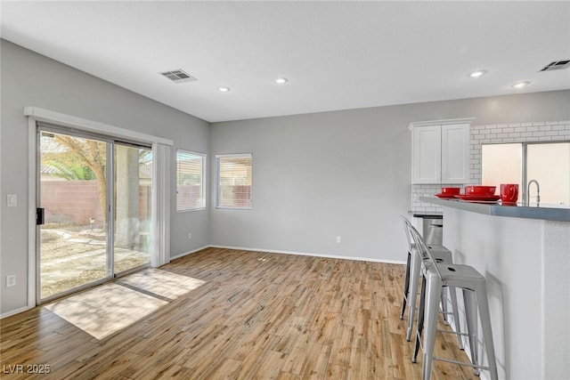 interior space featuring light wood finished floors, visible vents, recessed lighting, and baseboards