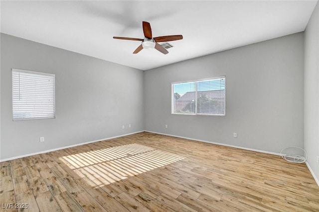 empty room featuring visible vents, baseboards, ceiling fan, and wood finished floors