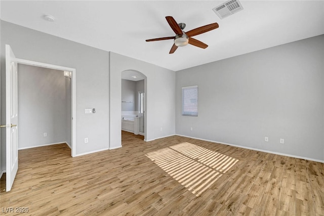 5919 Pavilion Lakes Ave, Las Vegas, NV 89122 - unfurnished bedroom with arched walkways, light wood-type flooring, ensuite bathroom, and ceiling fan